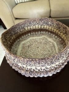 Hand-crocheted yarn basket perfect for home decor and storage.