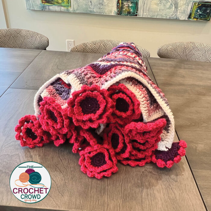 A pile of crocheted flowers on a table.