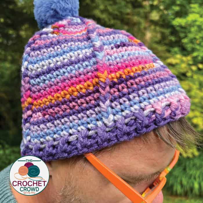 Colorful striped crochet beanie hat with pom-pom, perfect for winter warmth.