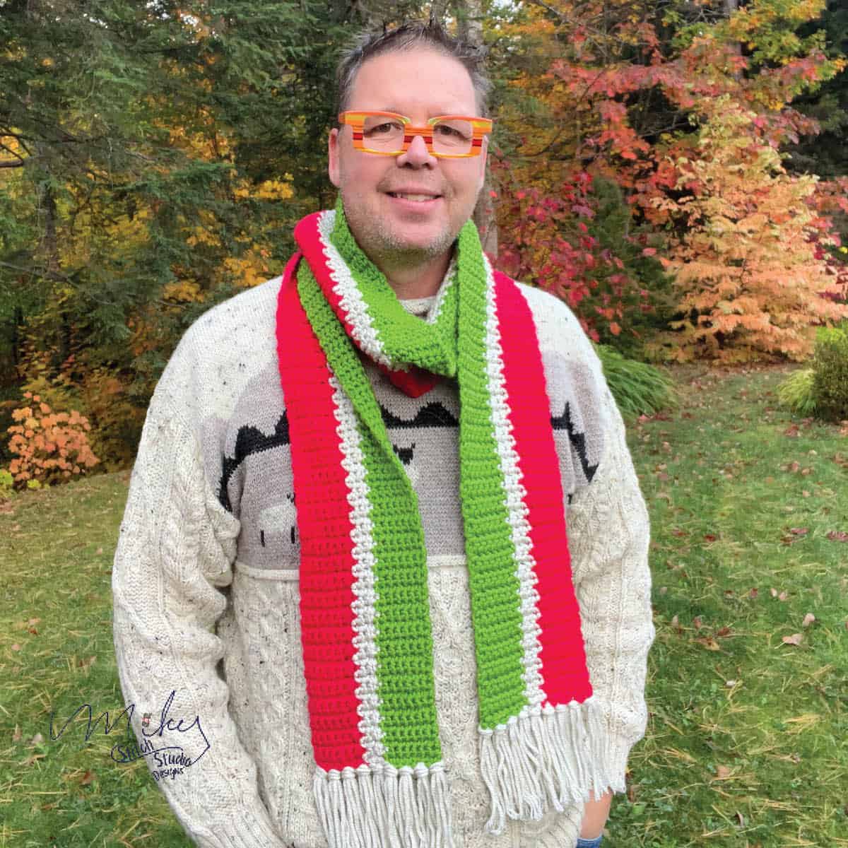 Man wearing crochet scarf in grinch colours. 