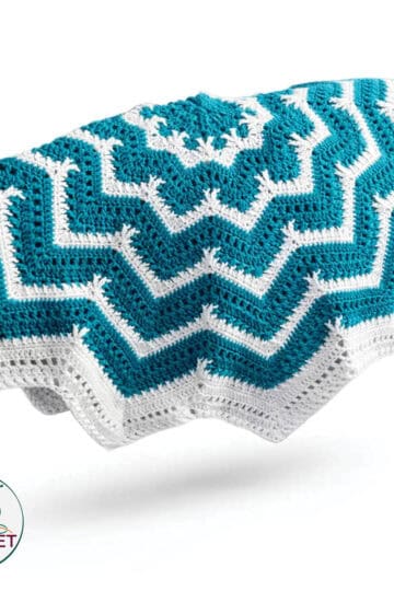 Bright blue and white Tunisian crochet blanket with intricate entrelac pattern.
